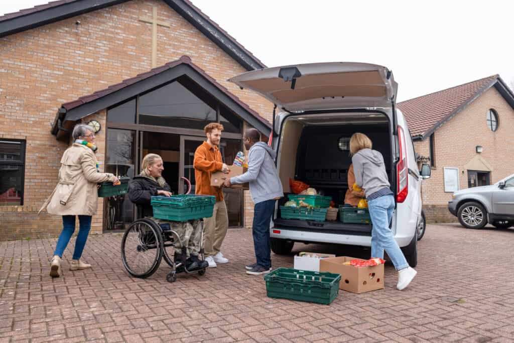 Volunteers loading food out of a truck at a church.